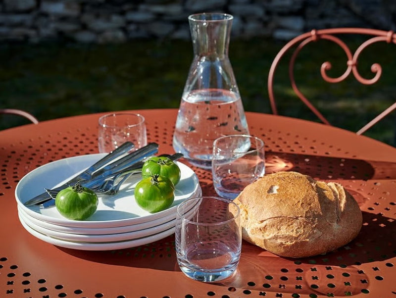 Load image into Gallery viewer, Fermob 1900 outdoor table with 96cm diameter, round metal table for patio or café settings, shown in a modern outdoor environment.