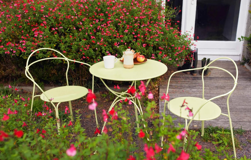 Load image into Gallery viewer, Fermob Airloop lounge chair with a modern, curved design, shown in a garden setting with a sleek, stylish appearance.