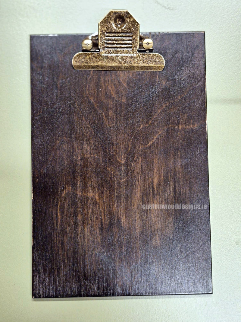 Load image into Gallery viewer, Set of 24 branded A5 wooden clipboards with Custom Wood Designs logo, displayed on a hospitality table for menus or notes.