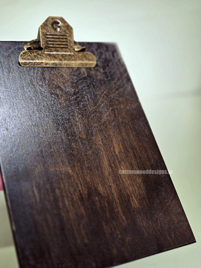 Load image into Gallery viewer, Set of 24 premium branded A5 wooden clipboards with Custom Wood Designs logo, displayed on a hospitality or cafe table.