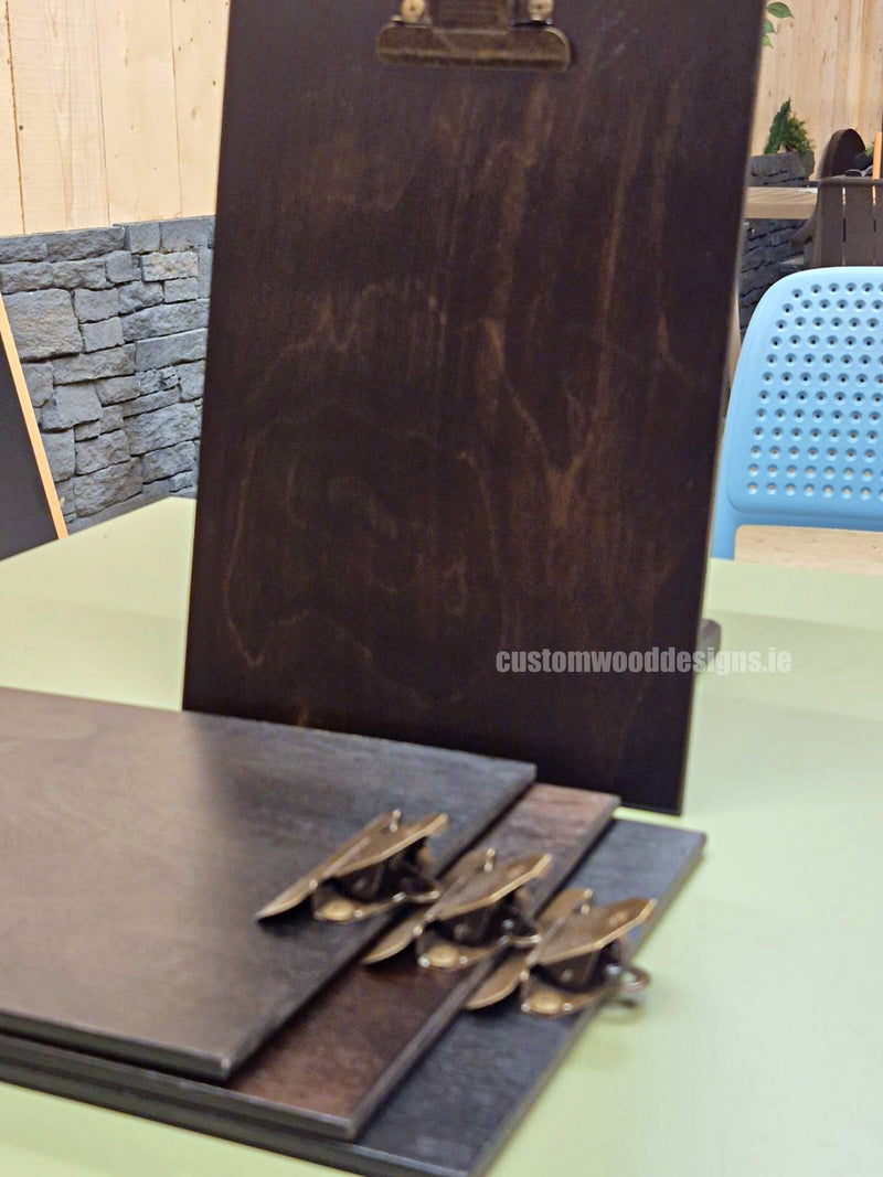 Load image into Gallery viewer, Set of 24 premium branded A4 wooden clipboards from Custom Wood Designs, displayed on a hospitality or café menu stand.