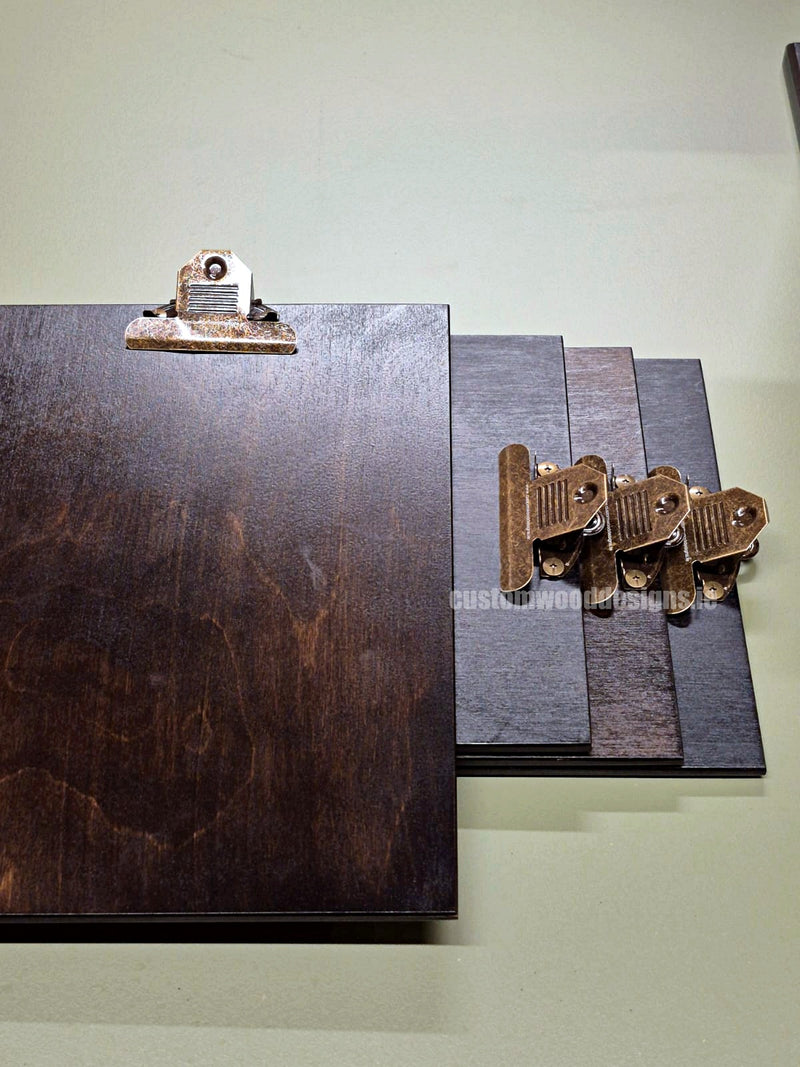 Load image into Gallery viewer, Set of 24 branded A4 wooden clipboards with Custom Wood Designs logo, displayed on a hospitality or cafe menu stand.