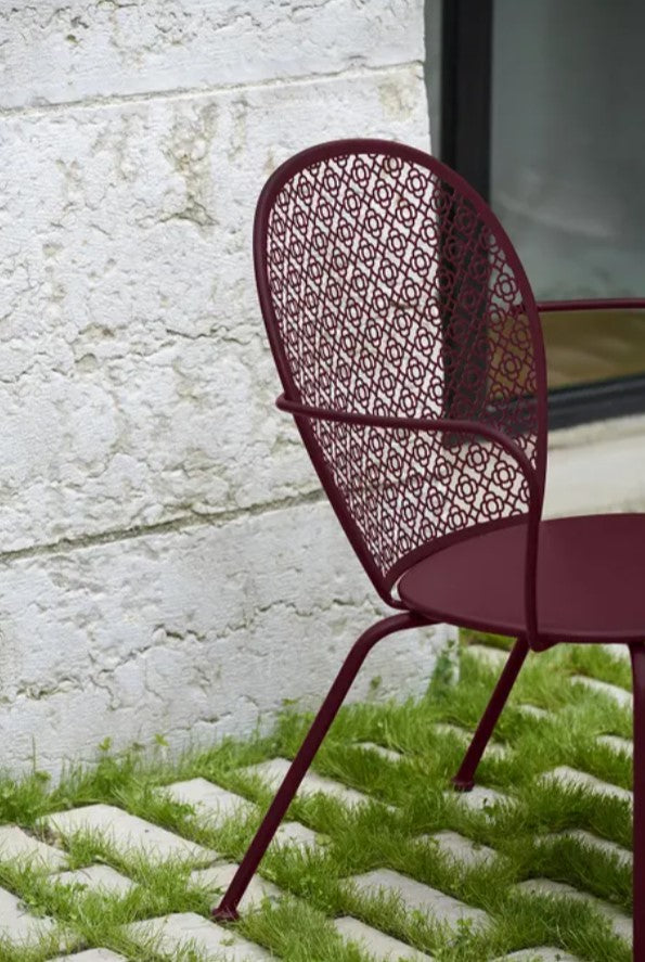 Load image into Gallery viewer, Fermob Lorette low armchair with a metal frame, featuring a stylish curved design for outdoor or hospitality seating.
