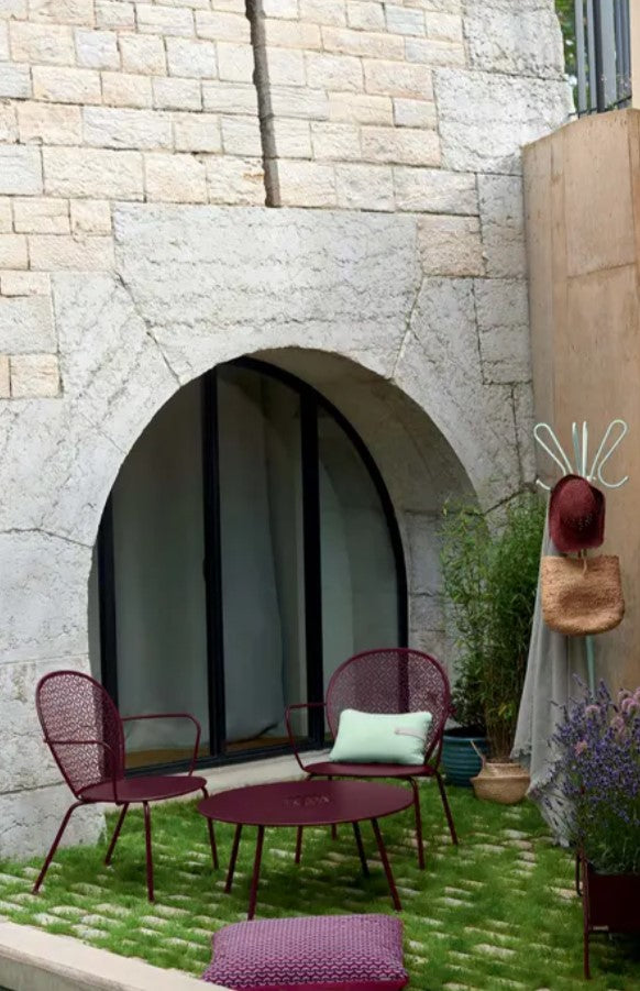 Load image into Gallery viewer, Fermob Lorette low armchair with a metal frame, featuring a modern design suitable for outdoor living and hospitality settings.