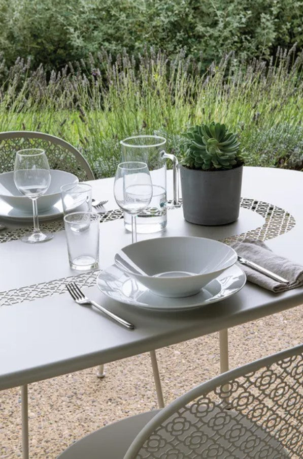 Load image into Gallery viewer, Fermob Lorette oval metal table, 160x90 cm, outdoor restaurant or hotel furniture, shown in a stylish hospitality setting.