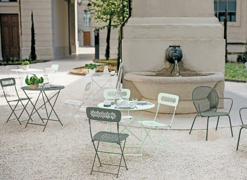 Load image into Gallery viewer, Fermob Lorette oval metal table, 160x90 cm, outdoor restaurant or hotel furniture, shown in a hospitality setting