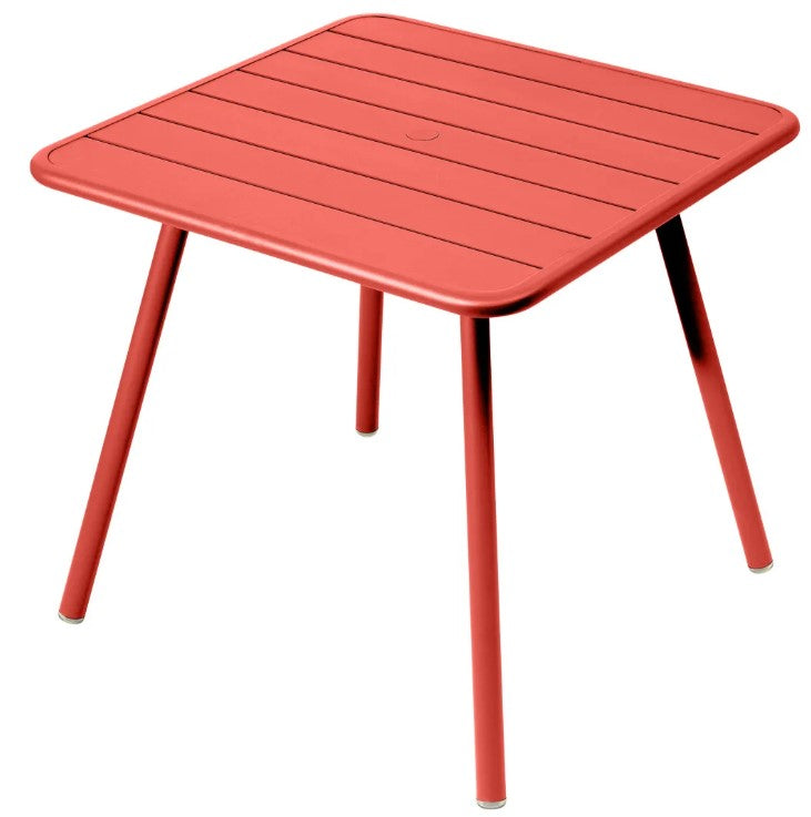 Load image into Gallery viewer, Fermob Luxembourg 4-leg garden table, 80x80 cm, metal with coral aluminum finish, suitable for outdoor patio or garden.