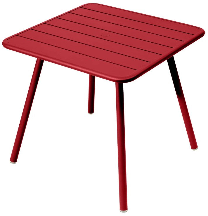 Load image into Gallery viewer, Red Fermob Luxembourg 4-leg garden table 80x80 with aluminum top, ideal for outdoor patio or garden settings.