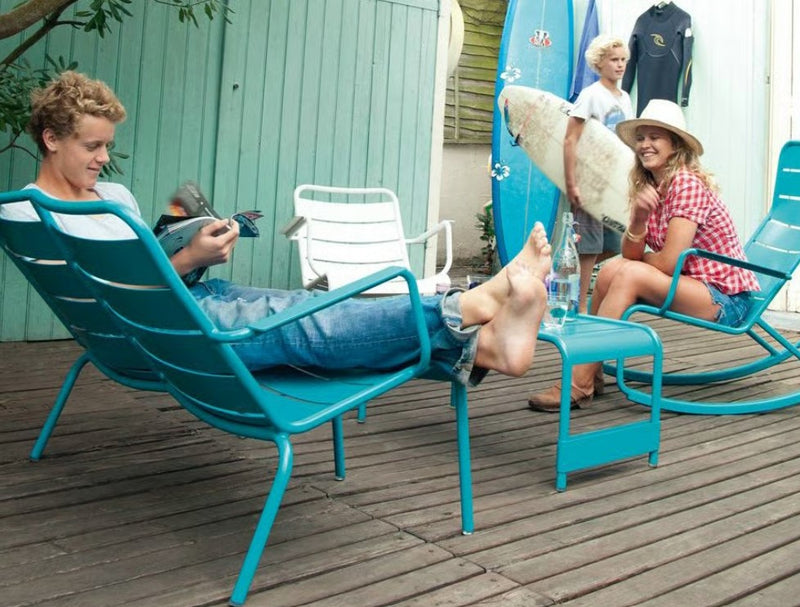Load image into Gallery viewer, Fermob Luxembourg outdoor rocking chair with blue metal frame, showcasing a modern, curved design for outdoor relaxation.