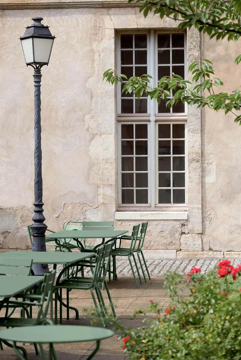 Load image into Gallery viewer, Fermob OPÉRA+ outdoor metal table with 67 cm diameter, suitable for patio or restaurant settings, shown on a patio surface.