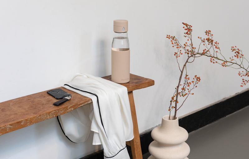 Load image into Gallery viewer, Ukiyo glass hydration tracking bottle with sleeve, clear drinkware for staying hydrated, features measurement markings and protective sleeve.