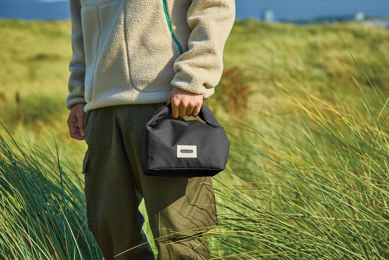 Load image into Gallery viewer, Black + Blum 6.7L insulated outdoor lunch and cooler bag with black exterior and zip closure, designed for keeping food fresh.