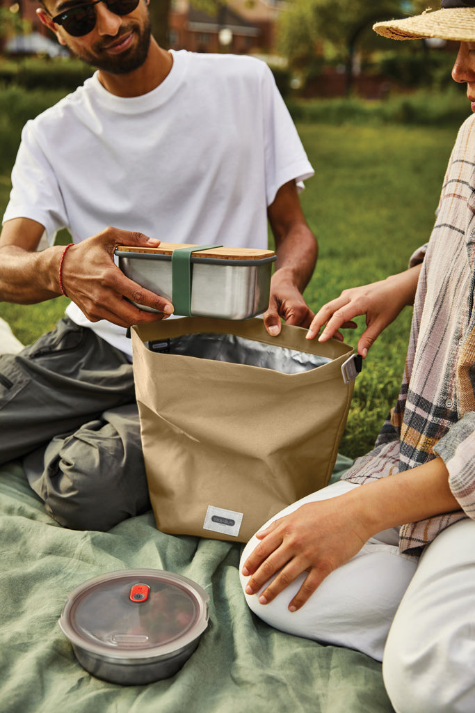 Load image into Gallery viewer, Black+Blum insulated outdoor lunch cooler bag with black exterior and adjustable shoulder strap, designed for easy carrying.