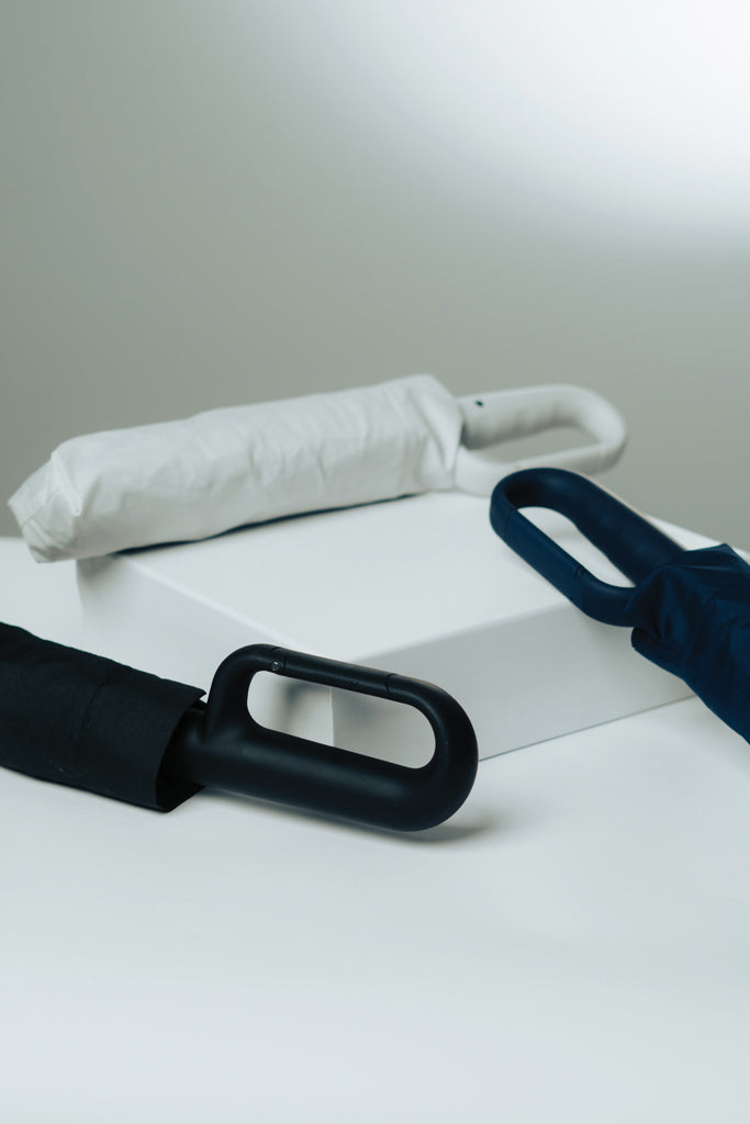Load image into Gallery viewer, XD Collection Yara 21-inch AWARE™ RPET solid color umbrella with carabiner, shown with open canopy and attached carabiner clip.