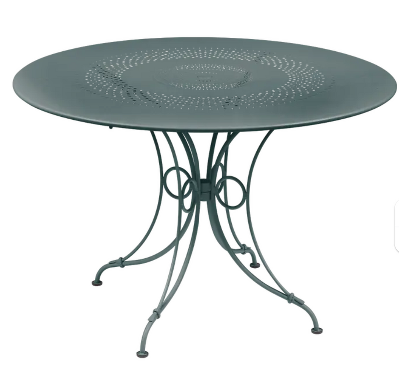 Load image into Gallery viewer, Storm Grey Fermob 1900 outdoor round table with 117cm diameter, featuring a sleek metal design for outdoor furniture.