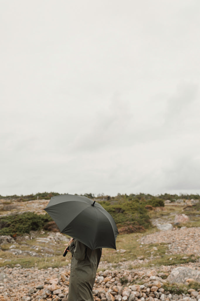 Load image into Gallery viewer, Vinga Baltimore AWARE™ RPET 23-inch umbrella open with navy canopy and curved handle, showcasing eco-friendly design and sturdy construction.