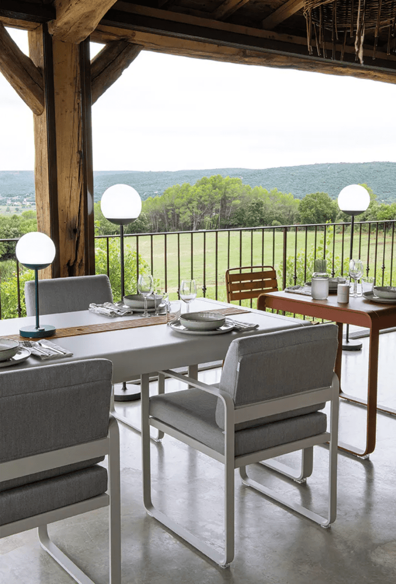 Load image into Gallery viewer, Fermob Bellevie outdoor dining armchair with a nutmeg grey toupet cushion and armrests, designed for comfortable outdoor seating.