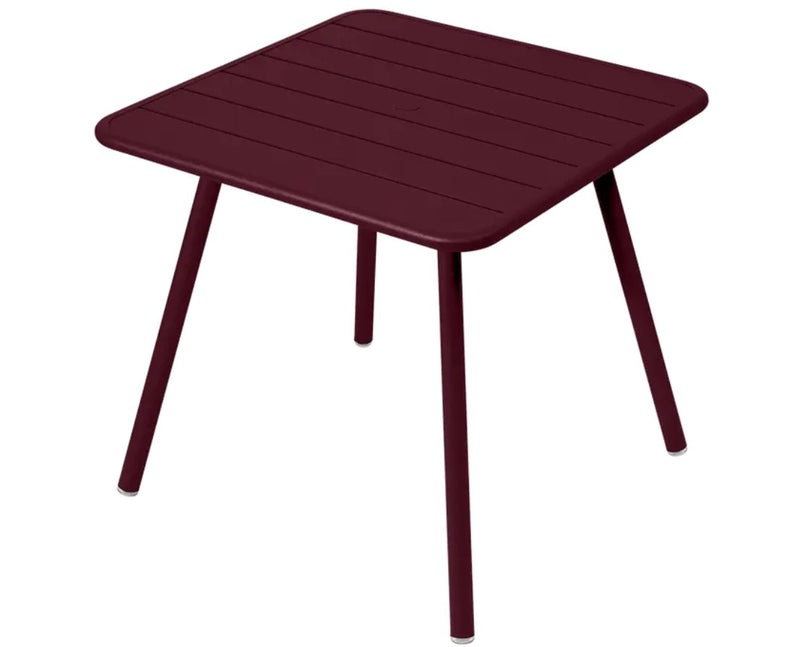 Load image into Gallery viewer, Dark cherry Fermob Luxembourg 4-leg garden table with 80x80 cm metal tabletop, suitable for outdoor use and modern garden decor.