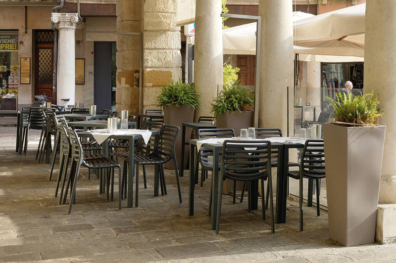 Load image into Gallery viewer, Nardi Doga outdoor armchair with curved wooden slats and metal legs, designed for patio or garden seating.