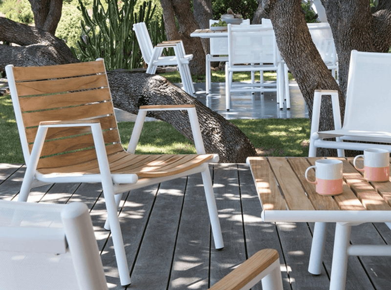 Load image into Gallery viewer, Red ochre Fermob Pilotis teak outdoor armchair with low arms, showcasing solid teak construction and modern design.