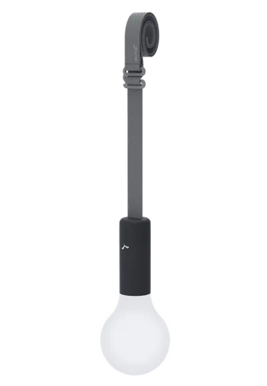 Fermob APLÔ suspended lamp with an anthracite finish and adjustable suspension strap, hanging as a stylish, rechargeable light.