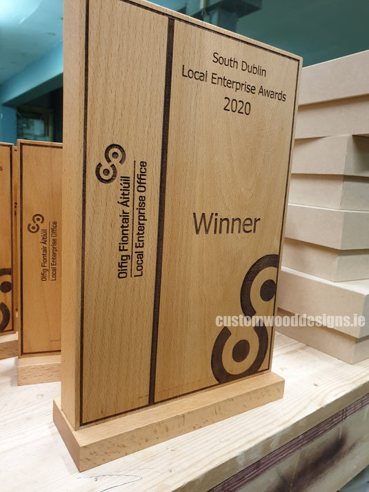 Custom Wood Designs award plaque with engraved branding, showcasing a polished wooden trophy for recognition and awards.