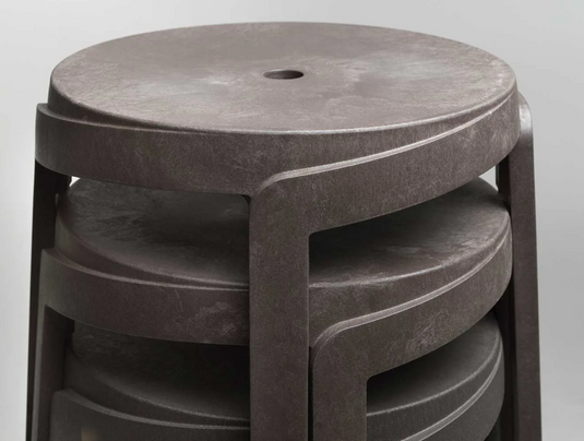 Nardi Basalto Stack Mini Stool outdoor chair made of sustainable material, shown stacked on a patio setting.
