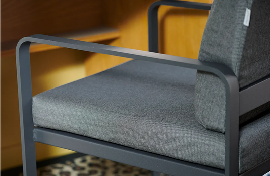 Fermob Bellevie outdoor dining armchair with a nutmeg gray finish, featuring a sturdy frame and comfortable armrests.