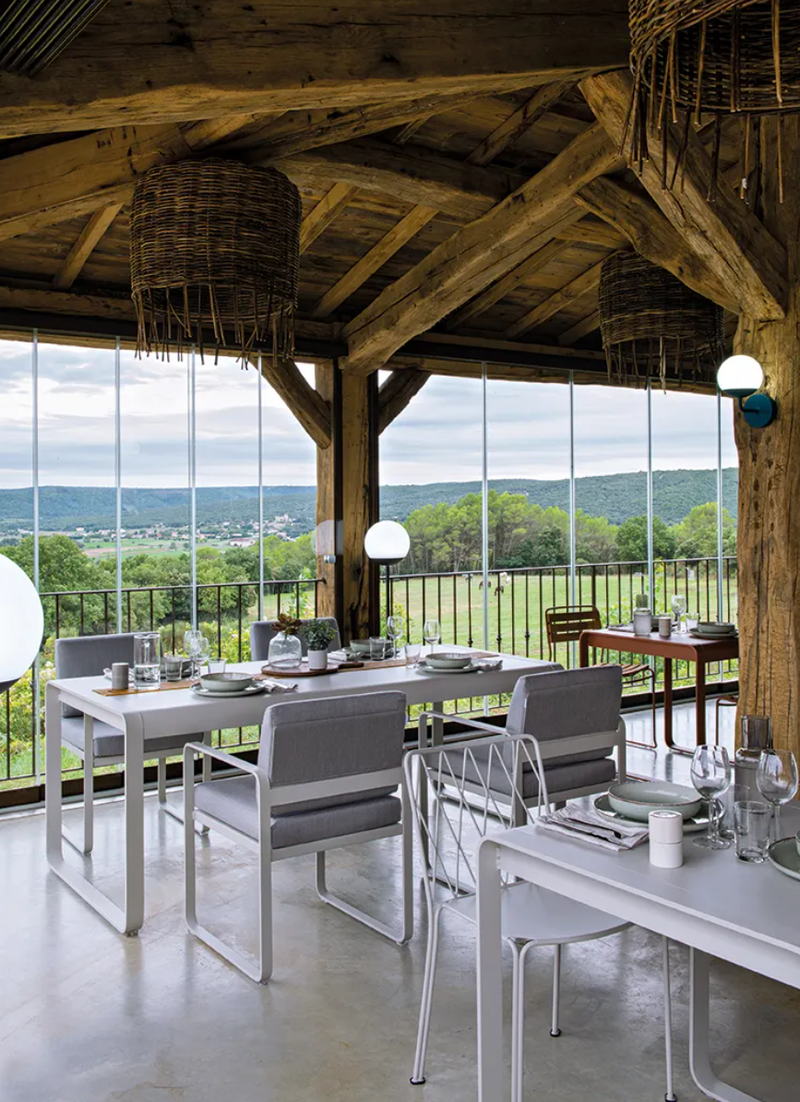 Load image into Gallery viewer, Fermob Bellevie outdoor dining armchair with a nutmeg grey finish, featuring a woven seat and armrests for outdoor dining comfort.
