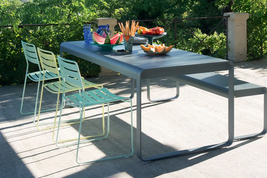 Fermob Bellevie outdoor metal dining table, 196 x 90 cm, eight-seater, with a sleek modern design in a garden setting.