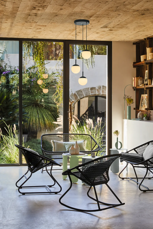 Black and white Fermob Sixties Low Armchair, woven lounge chair with a stylish, modern design for restaurant or home use.