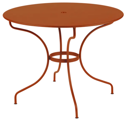 Orange Fermob OPÉRA+ outdoor metal table with a 96 cm diameter, designed for five-seater patio dining.