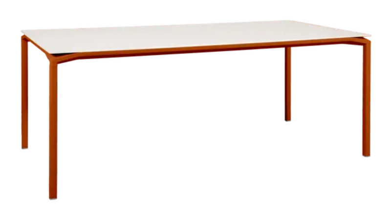 Load image into Gallery viewer, Fermob CALVI AERIS mineral dining table with eight seats, 195x95 cm, featuring a sleek, modern design and vibrant orange tabletop.
