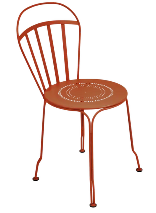 Fermob Louvre outdoor chair in Candied Orange with a curved metal design and slatted seat, ideal for garden or patio seating.