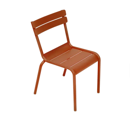 Fermob Luxembourg Kid Chair in candied orange color, lightweight plastic kids' chair with a modern design for children.