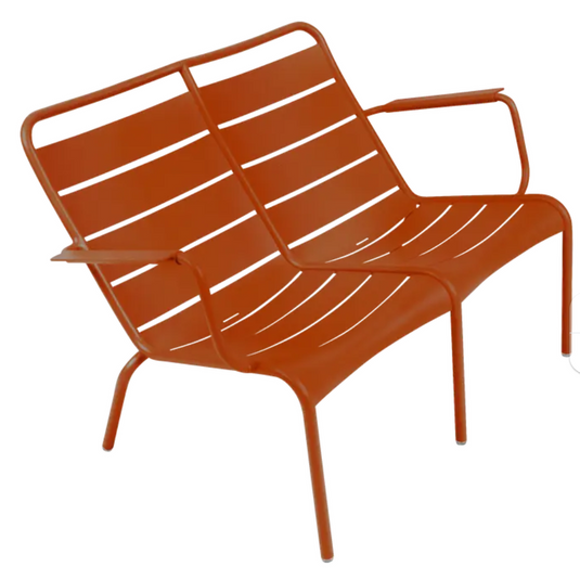 Luxembourg Duo low armchair by Fermob, featuring vibrant candied orange color and modern design in a stylish kids' corner setting.
