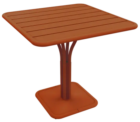 Fermob Luxembourg outdoor pedestal table with a candied orange finish, 80x80 cm, suitable for patio or garden use.