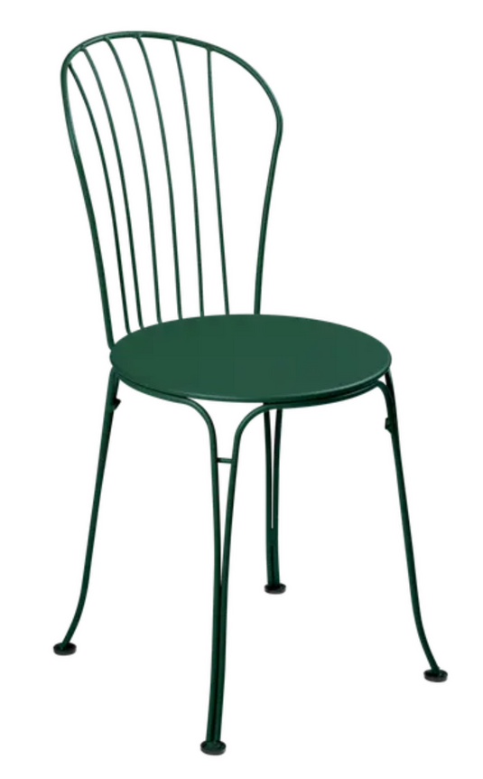 Cedar green Fermob OPÉRA+ metal outdoor chair with curved backrest and armrests, suitable for patio or restaurant outdoor seating.