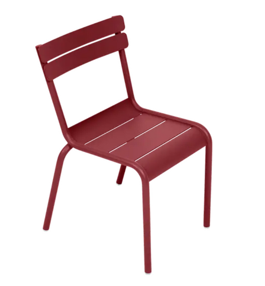 Fermob Luxembourg Kid Chair in vibrant Chili color, designed for children, with a sturdy, modern restaurant-style appearance.