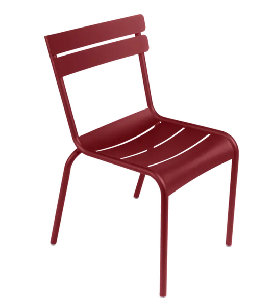 Red Fermob Luxembourg armchair with a metal frame, stackable design, suitable for outdoor or restaurant seating.