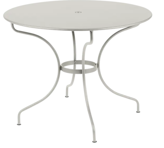 Fermob OPÉRA+ outdoor metal table with a 96 cm diameter in Cley Grey, suitable for five people on patio or garden.
