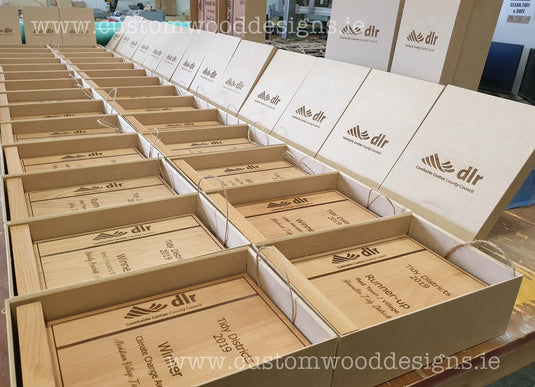 Custom Wood Designs custom made awards with engraved plaques and elegant wooden bases, suitable for recognition and achievement.