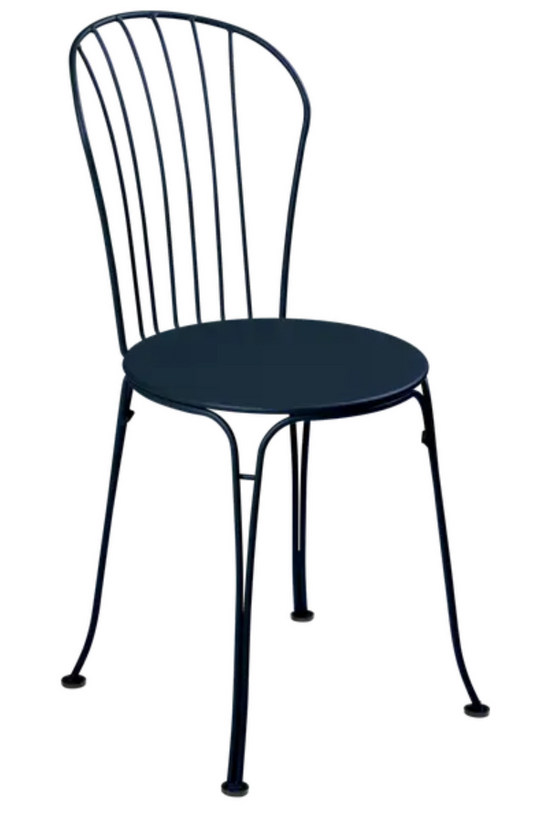 Deep blue Fermob OPÉRA+ metal outdoor chair with curved armrests and slatted seat, suitable for restaurant or patio seating.