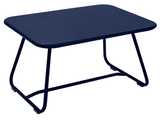Deep blue Fermob Sixties low outdoor table measuring 76x55.5cm, designed for stylish outdoor seating areas.