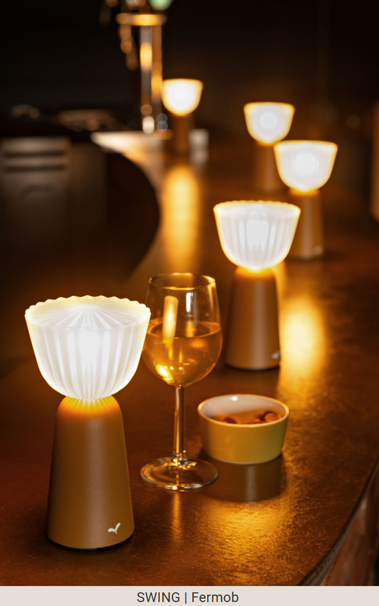 Set of 6 Fermob Swing rechargeable outdoor lamps with charging tray, stylish and portable lighting for outdoor spaces.