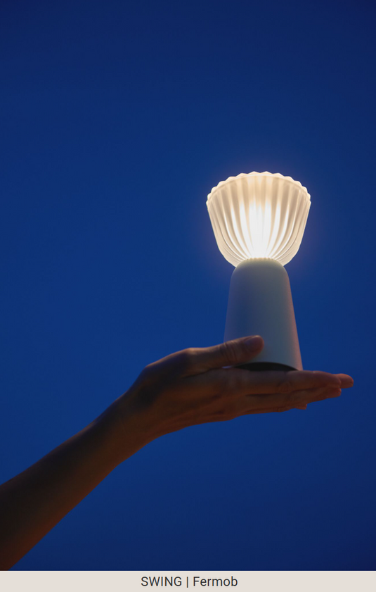 Set of six Fermob Swing rechargeable outdoor lamps with charging tray, stylish portable lighting for outdoor spaces.