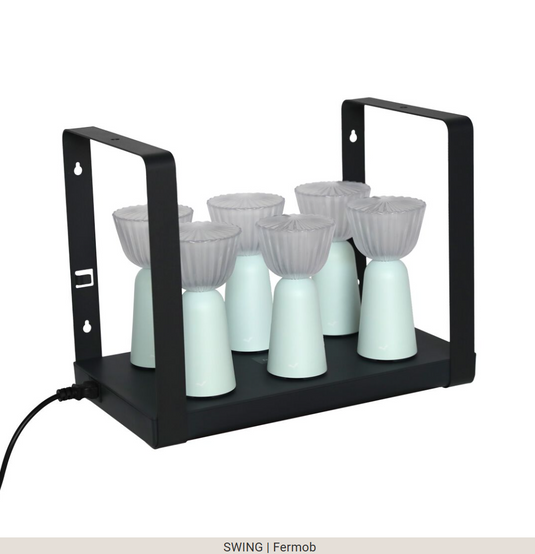 Set of six Fermob Swing rechargeable outdoor lamps with charging tray, stylish and portable lighting for outdoor spaces.