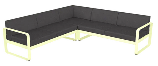 Fermob Bellevie Composition 2 outdoor sofa set with frosted lemon and graphite grey cushions on a patio.