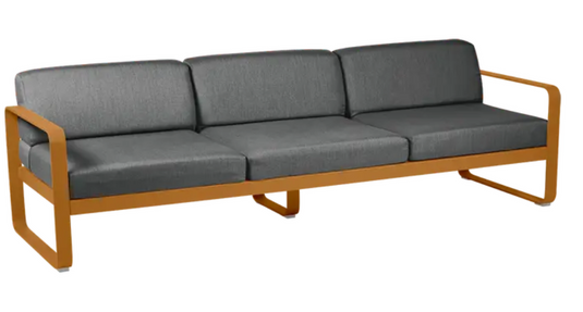 Fermob Bellevie 3-seater outdoor sofa with metal frame in grey, shown with plush cushions on a patio setting.