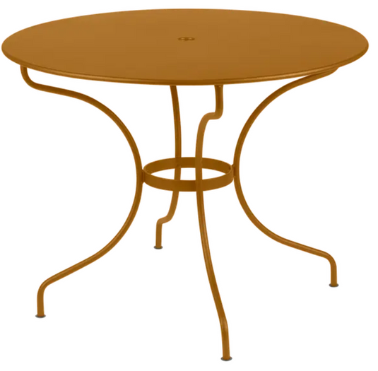 Fermob OPÉRA+ outdoor metal table with 96cm diameter, five-seater design, in a gingerbread color for patio or garden use.